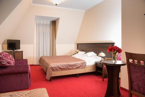 a hotel room with a bed and a red carpet at Zajazd u Beaty i Violetty in Kawice