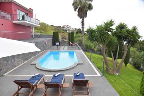 a swimming pool with lounge chairs at Quinta do Brasil in Arco da Calheta