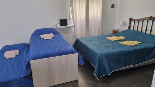 duas camas com lençóis azuis num quarto em Don Roque II em Santa Rosa