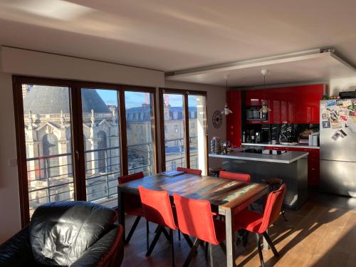 eine Küche mit einem Holztisch und roten Stühlen in der Unterkunft Issy - les jardins du séminaire in Issy-les-Moulineaux
