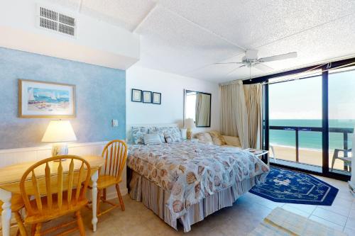 a bedroom with a bed and a table and chairs at Golden Sands 714 in Ocean City