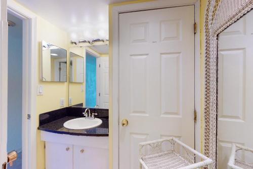 a bathroom with a sink and a white door at Golden Sands 714 in Ocean City