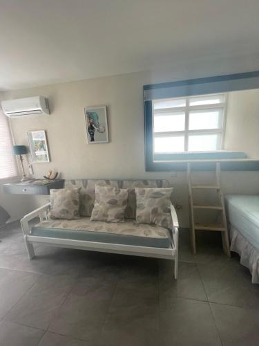 1 dormitorio con cama con almohadas y ventana en Scarlett Studios - Holiday-Business-US Embassy Appt 7 mins drive away - The one night only rate includes Airport and Embassy transportation, en Bridgetown