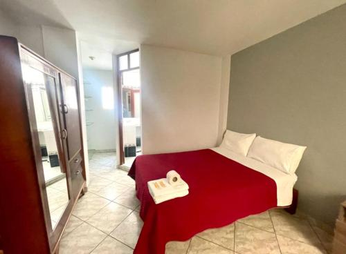 - une chambre avec un lit et une couverture rouge dans l'établissement Apartamento Sotillo, à Ilo