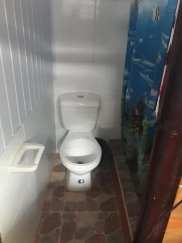 bagno con servizi igienici bianchi in una cabina di Hostal tachiwa a Puerto Nariño