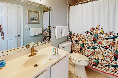 La salle de bains est pourvue de toilettes et d'un rideau de douche avec des oiseaux. dans l'établissement Gulf Dunes W 512, à Fort Walton Beach