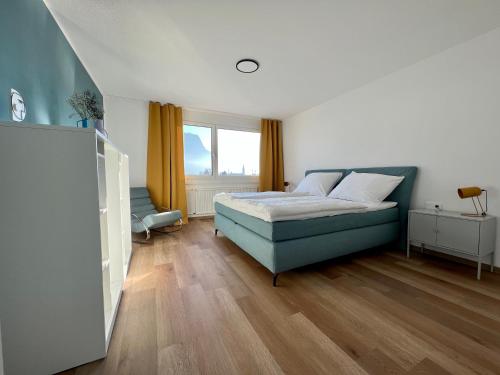 a bedroom with a blue bed and a window at Apartment Popular in Dornbirn