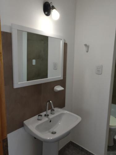 y baño con lavabo blanco y espejo. en Yexalen PB en El Calafate