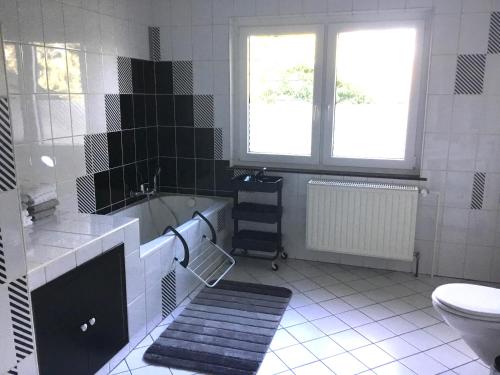 a bathroom with a tub and a toilet and a sink at Holiday Apartment 4you in Butgenbach