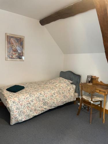 une chambre avec un lit, une table et un bureau dans l'établissement Les Granges du Bois Normand, à Rueil-la-Gadelière