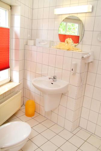 a white bathroom with a sink and a mirror at Hotel Müritzterrasse in Röbel