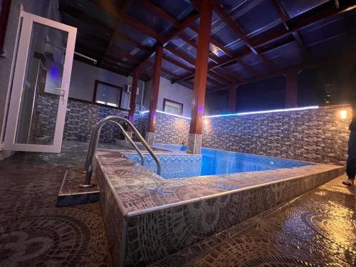 een jacuzzi in een kamer met een stenen muur bij Villa Nador in Nador