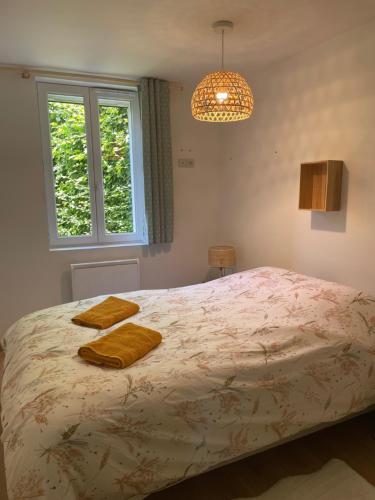 a bedroom with a bed with two towels on it at Le Jardin de Juliette in Gournay