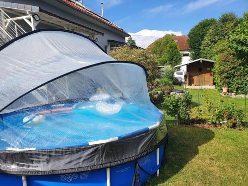 Niebieski samochód zaparkowany na trawie przed domem w obiekcie Kornhaus - schöne Ferienwohnung mit Pool, Kamin und Terrasse w Getyndze