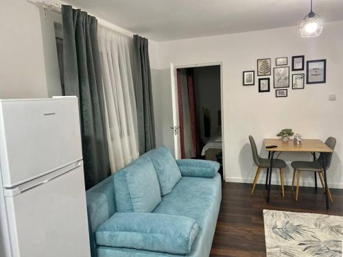 a living room with a blue couch and a table at EDA apartment in Bistriţa