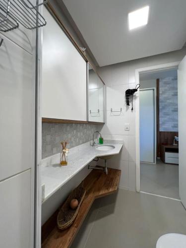 a white bathroom with a sink and a mirror at Condado Aldeia dos Reis 311 in Mangaratiba