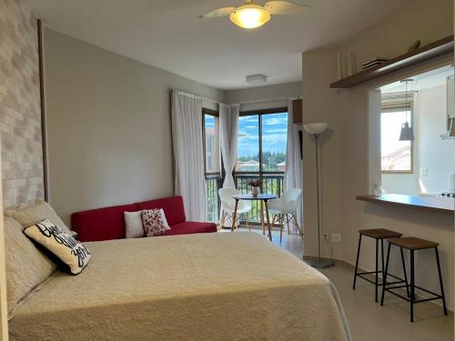 a bedroom with a bed and a kitchen with a table at Condado Aldeia dos Reis 311 in Mangaratiba