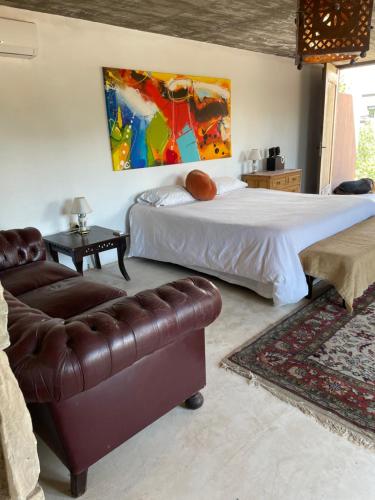 1 dormitorio con cama y sofá de cuero en Loft Boutique Chacras de Coria en Luján de Cuyo