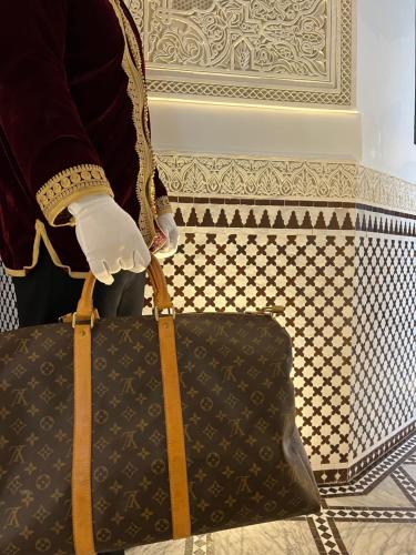 a person holding a black bag with a glove on it at Palais De Fès Suites & Spa in Fez