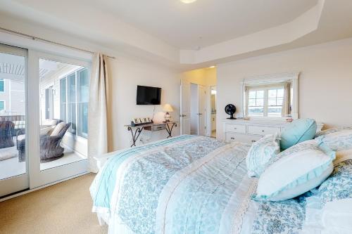 a bedroom with a large bed and a balcony at Laguna Bay - 37292 Lighthouse #201 in Selbyville
