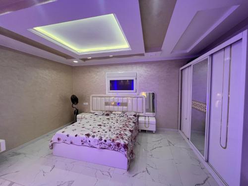 een slaapkamer met een bed en een televisie aan het plafond bij Villa Nador in Nador