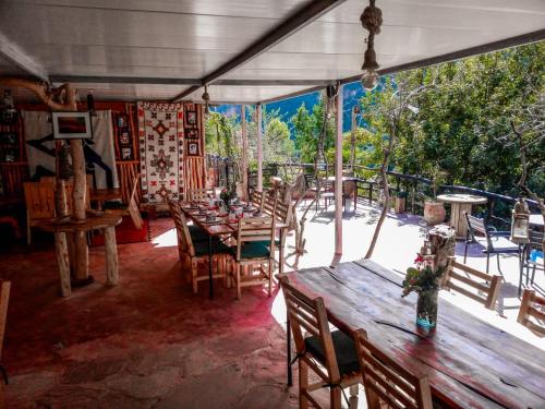 una sala da pranzo con tavoli, sedie e una grande finestra di Dar l'eau Vive a Bine el Ouidane
