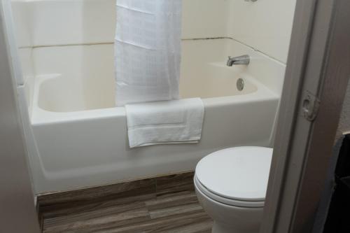 a bathroom with a white toilet and a sink and a tub at AmericInn by Wyndham Madison WI in Madison