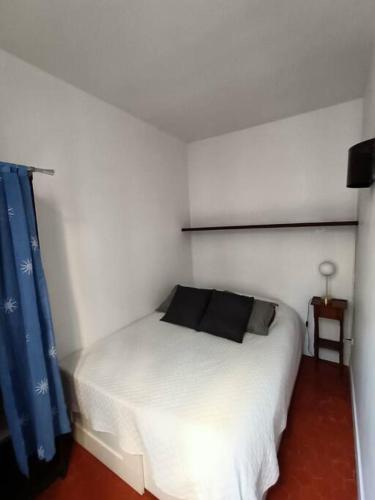 - une chambre avec un lit blanc et un oreiller noir dans l'établissement T2-Avignon - centre historique, à Avignon