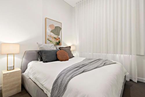 - une chambre avec un grand lit blanc et des oreillers dans l'établissement 3 Bedroom Apartment over looking Newcastle, à Newcastle