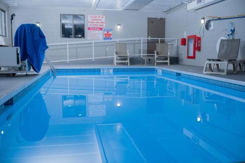 una piscina con agua azul en una habitación en AmericInn by Wyndham Madison WI, en Madison