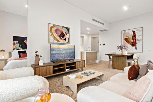 uma sala de estar com mobiliário branco e uma televisão de ecrã plano em 3 Bedroom Apartment over looking Newcastle em Newcastle