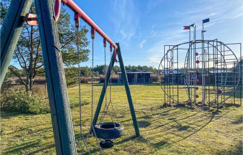 an empty playground with a swing set in a field at Kerstins Stuga in Visby