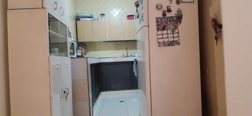 una pequeña cocina con armarios blancos y fregadero en cambulos 2, en Cali