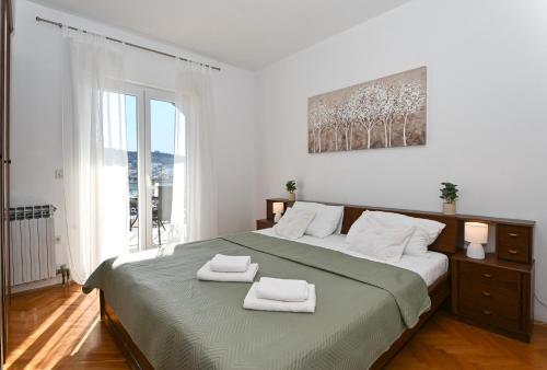 a bedroom with a large bed with two towels on it at Holiday house Vukman in Trogir