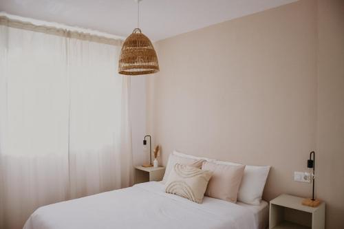 ein Schlafzimmer mit einem weißen Bett mit weißen Kissen in der Unterkunft Casa Mahalo - Modern Apartment with Pool, Minutes from Spectacular Beaches in Parque Holandes