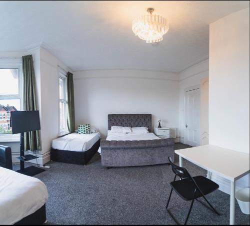 - une chambre avec deux lits, un canapé et un lustre dans l'établissement Howard House, à Southampton