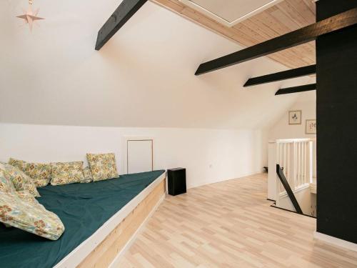 a bedroom with a bed and a wooden floor at Holiday home Lemvig IV in Ferring