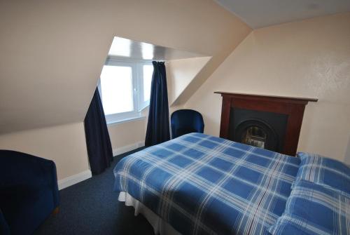 a hotel room with a bed and a fireplace at Saucy Mary's Hostel in Kyleakin