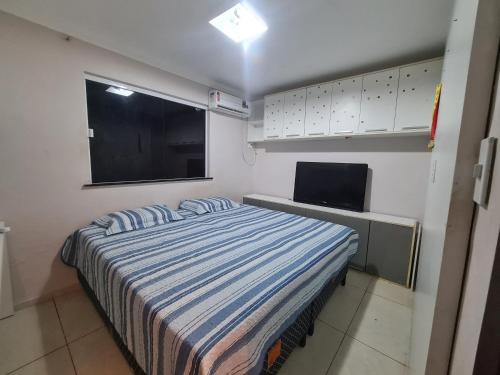 Schlafzimmer mit einem Bett und einem Flachbild-TV in der Unterkunft Casa Inteira com 3 Quartos in São Luís