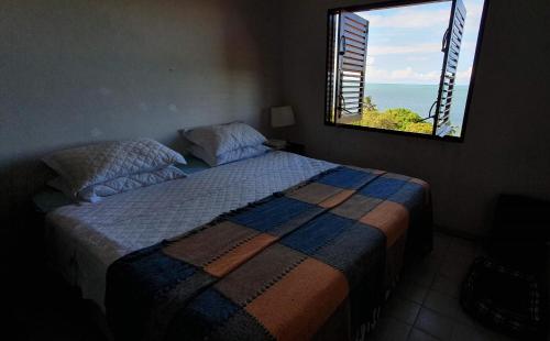 sypialnia z łóżkiem i widokiem na ocean w obiekcie Marina do Pássaro w mieście Goiana