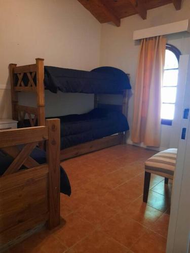 a bedroom with a bunk bed and a window at Casa El Encuentro in La Cieneguita