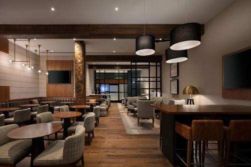 a restaurant with tables and chairs and a bar at Louisville Marriott Downtown in Louisville