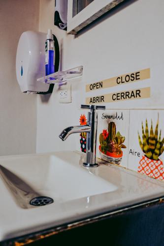 a kitchen sink with a soap dispenser above it at Hostel Metro Floresta Alojamiento in Medellín