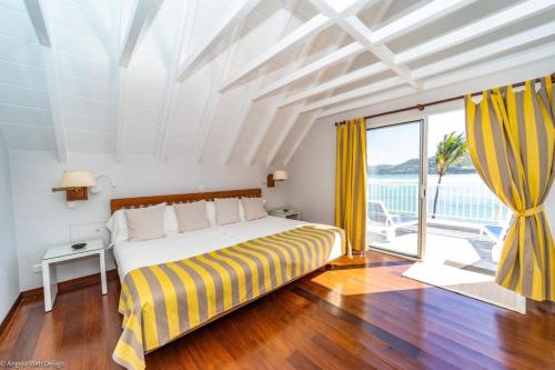 um quarto com uma cama e uma grande janela em Villa DAHOUET em Saint Barthelemy