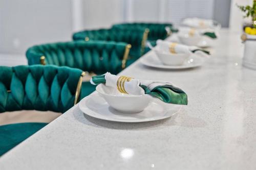 a table with bowls and plates on it with green chairs at *The 4Seasons:Themed Retreat w/Hot Tub-Pool Table* in Decatur