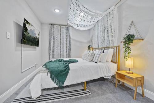 een witte slaapkamer met een bed en een kroonluchter bij *The 4Seasons:Themed Retreat w/Hot Tub-Pool Table* in Decatur