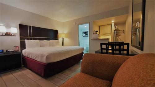 Habitación de hotel con cama y sofá en South Padre Island Lodge, en South Padre Island