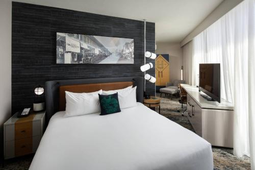 a bedroom with a bed and a desk and a television at Luminary Hotel & Co., Autograph Collection in Fort Myers