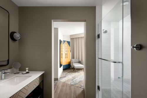 a bathroom with a sink and a glass shower at Luminary Hotel & Co., Autograph Collection in Fort Myers