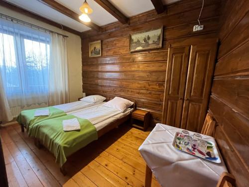 1 dormitorio con 2 camas en una habitación con paredes de madera en Noclegi NADZAMCZE, en Czorsztyn